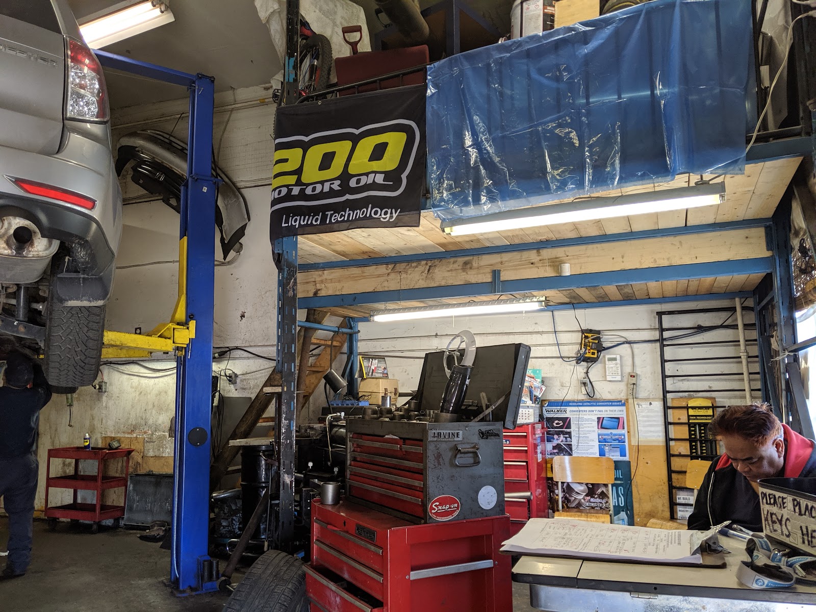 Inside Felix Muffler — car on the lift, toolbox, mechanic at the counter